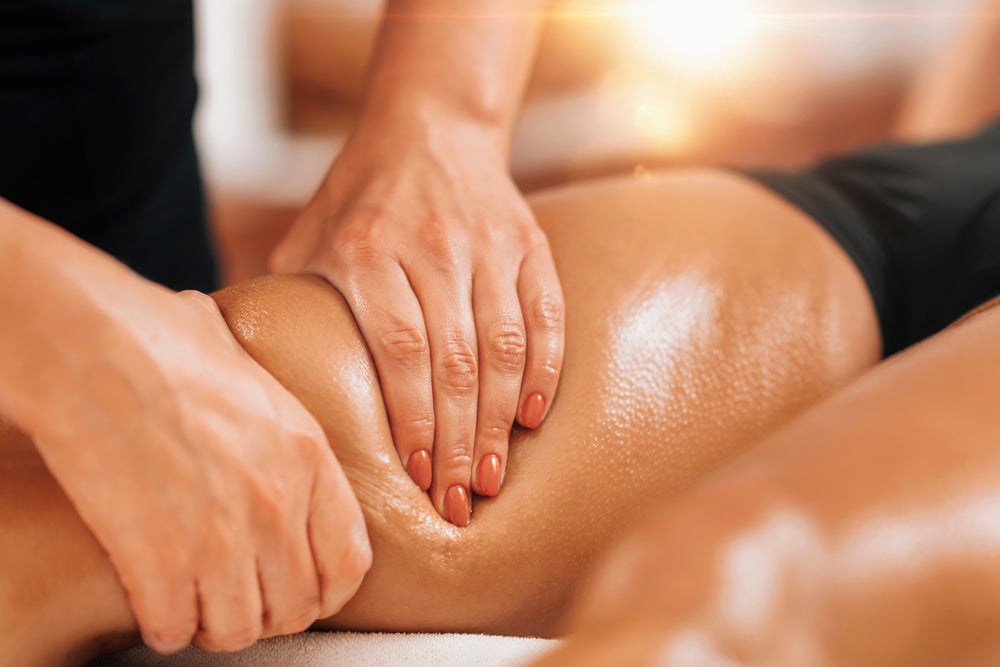 Lymphatic drainage massage. Hands of a masseuse massaging leg of a female client